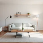 A small living room with low sofa, long table, tall lamp, rug and wall shelf, showing leggy furniture.